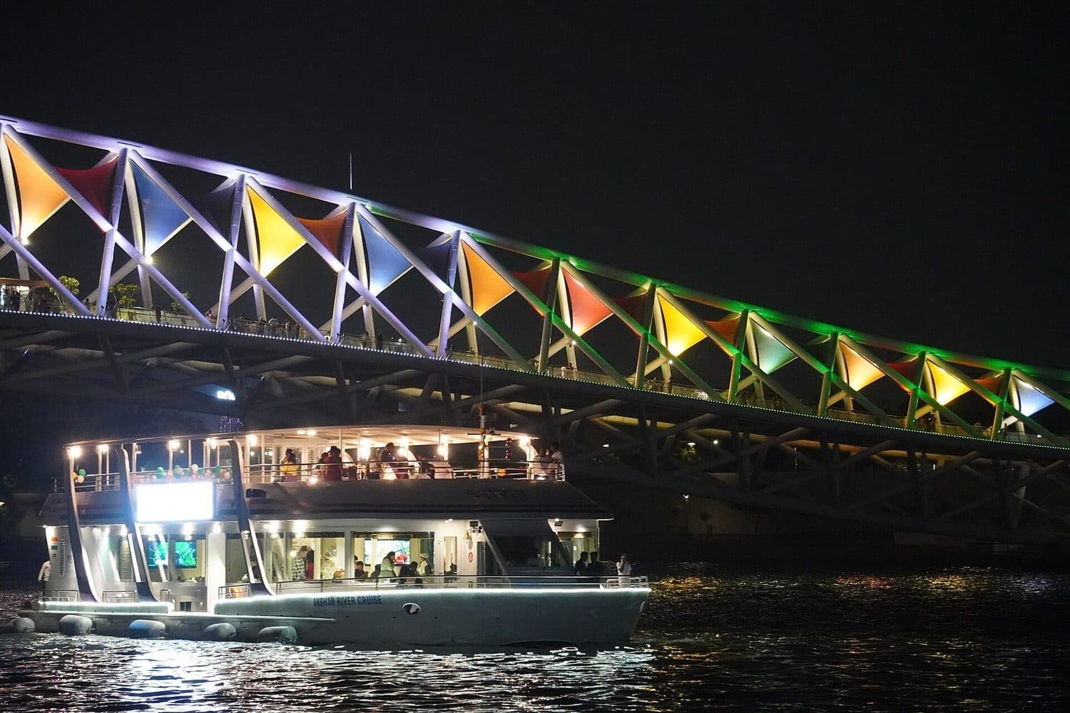 A river cruise passing beneath the Atal pedestrian bridge on the Sabarmati